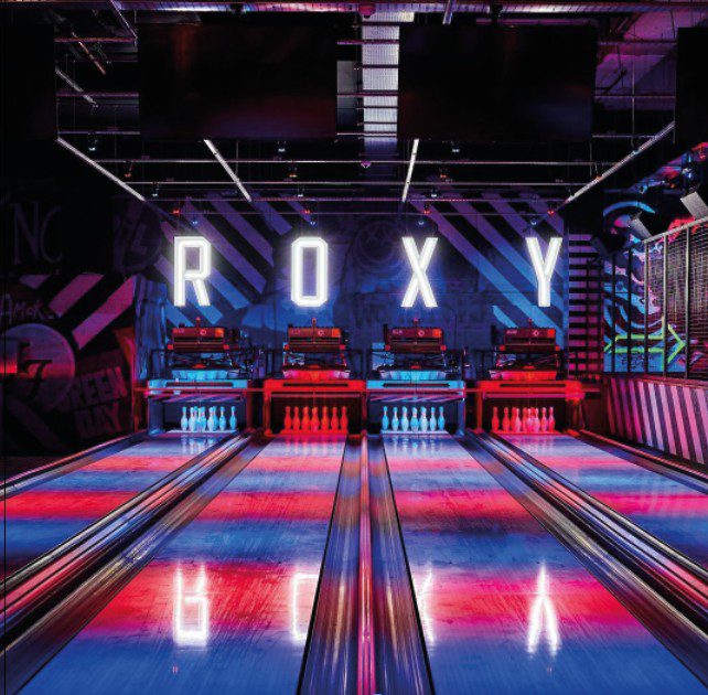 Competitive Socializing - Multiple lanes of a colourfully lit bowling alley