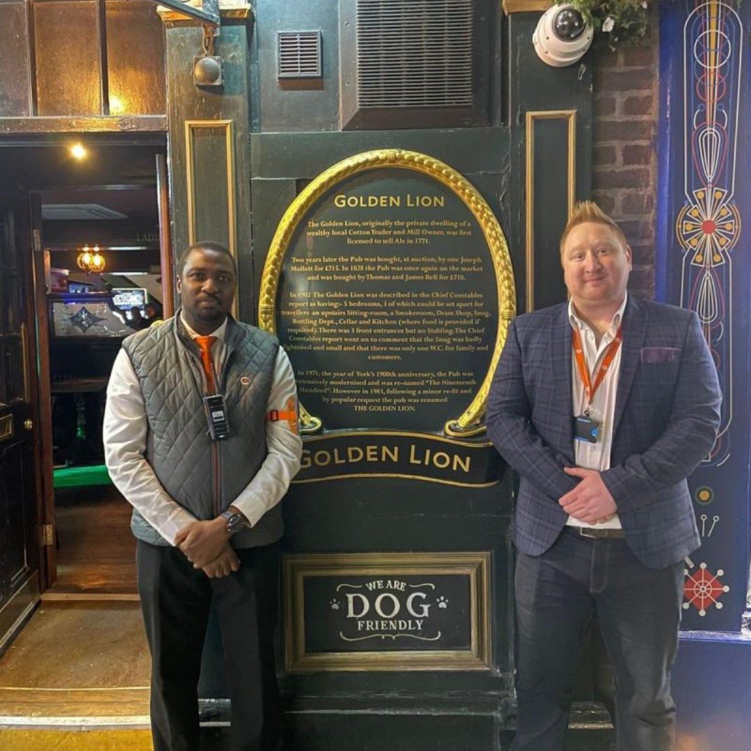 2 men stood in front of a sign